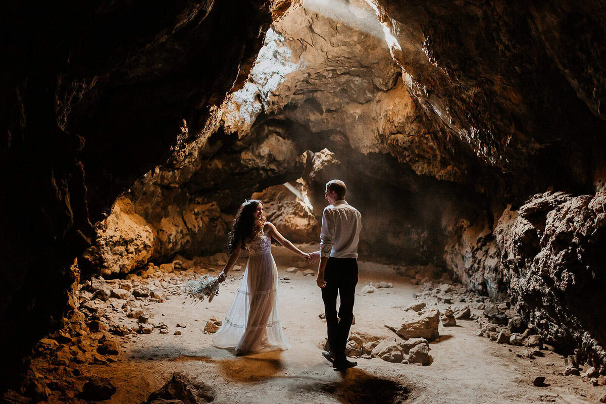 An adventurous wedding couple enjoys their elopement day while exploring a cave in the California Desert. 