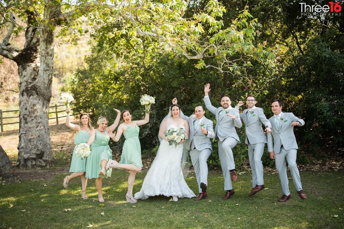 Wedding Party jump for joy with the Bride and Groom