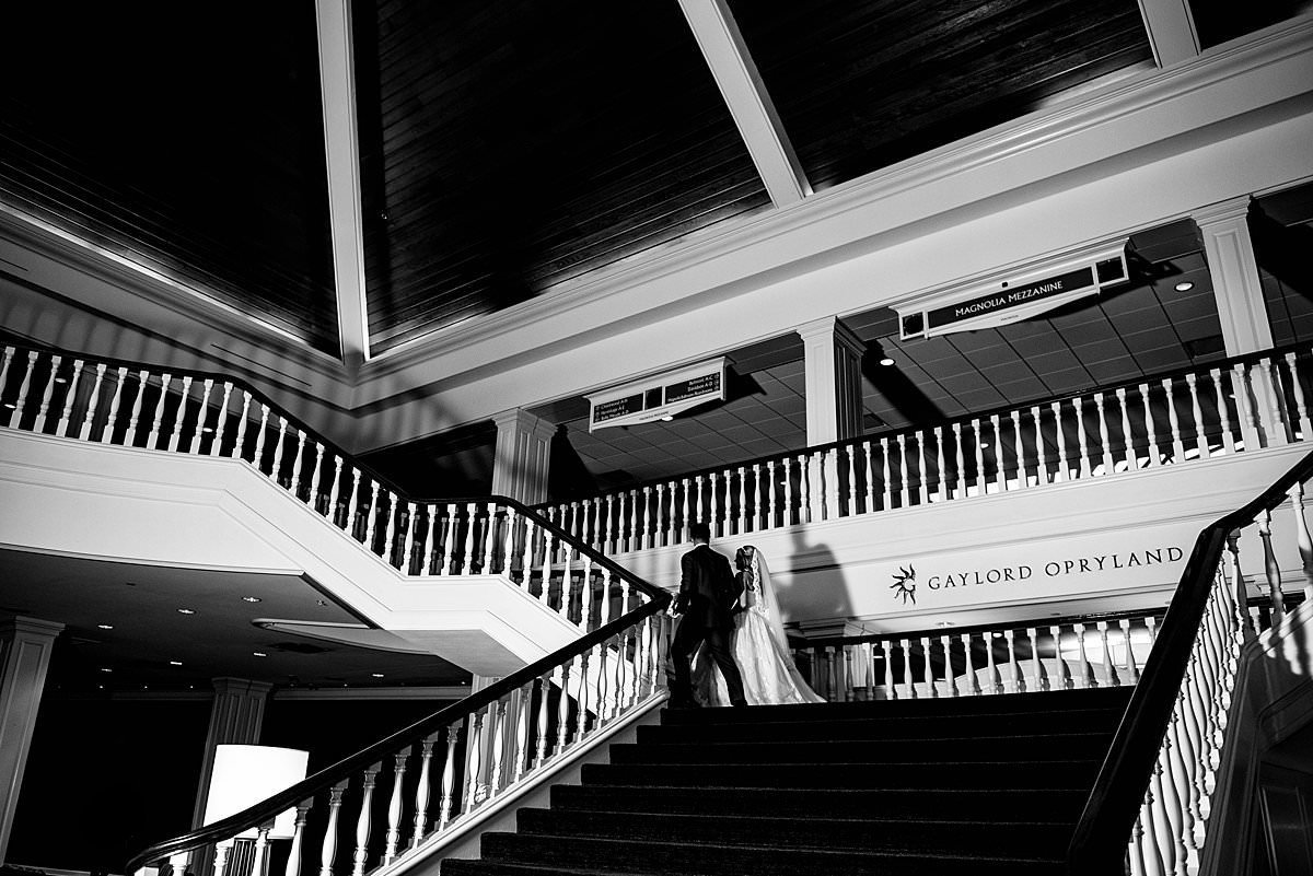 Black and white photo of couple walking up staircase inside of Gaylord Opryland