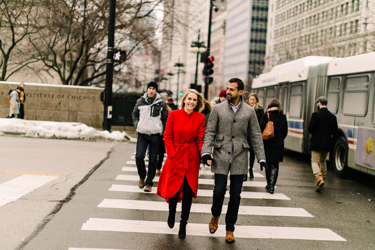A candid engagement photo of a couple crossing Michigan Avenue
