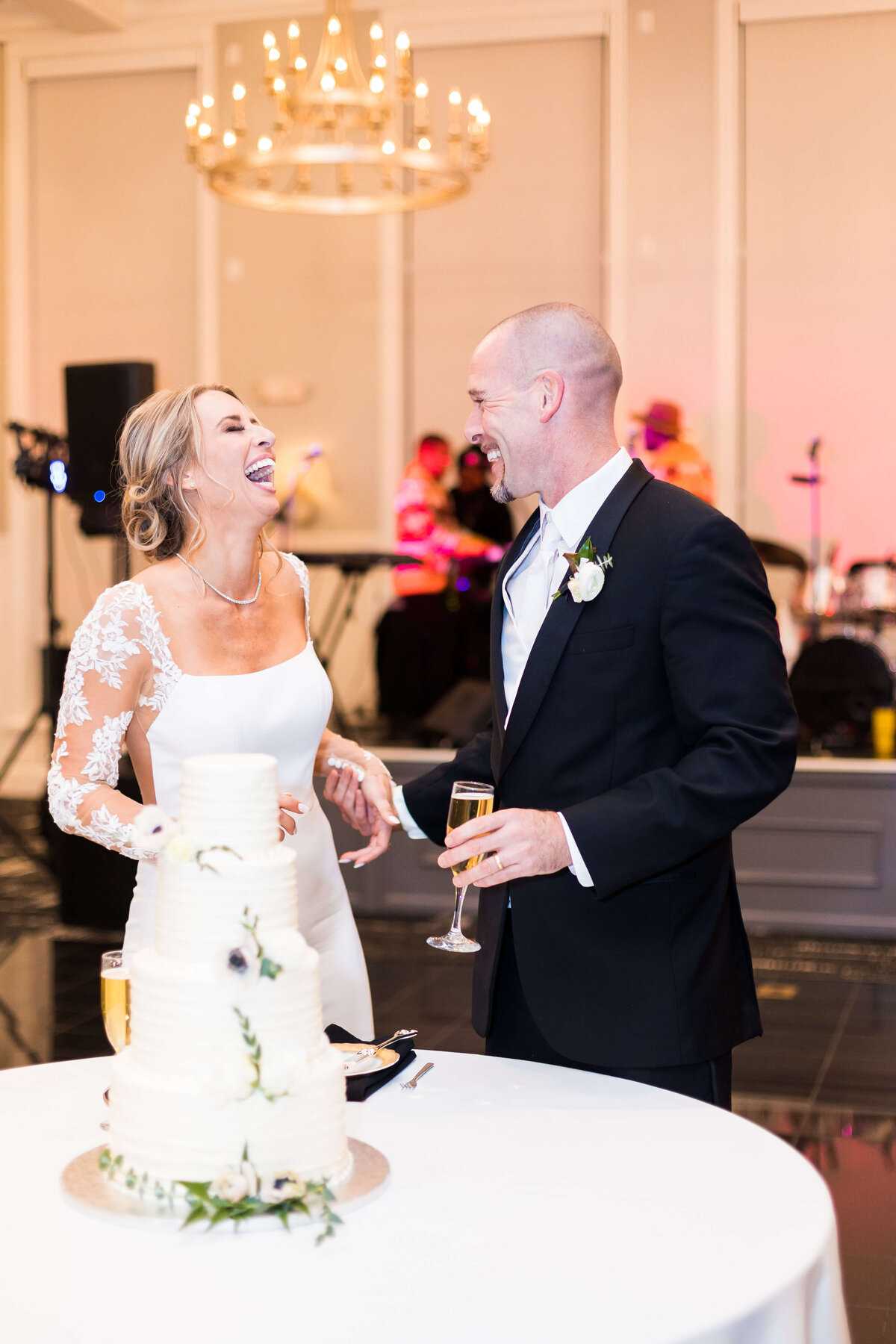 Bride and groom laughing standing by wedding cake at The Carrick House Wedding venue in Lexington, KY