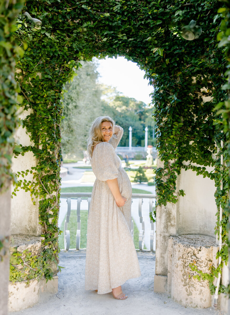 A serene maternity portrait set in a dreamy garden, captured by Claudia Amalia Maternity Photography.