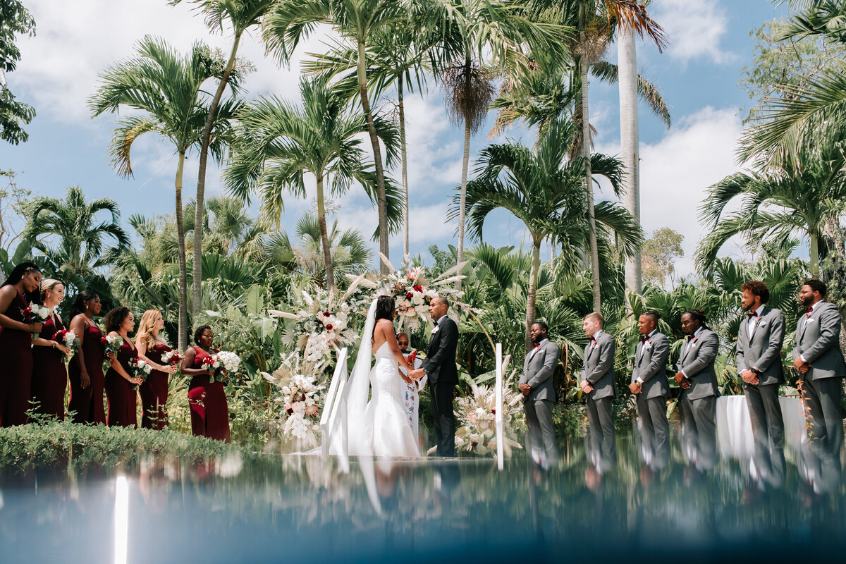 Couple saying their vows under palm trees in the Bahamas