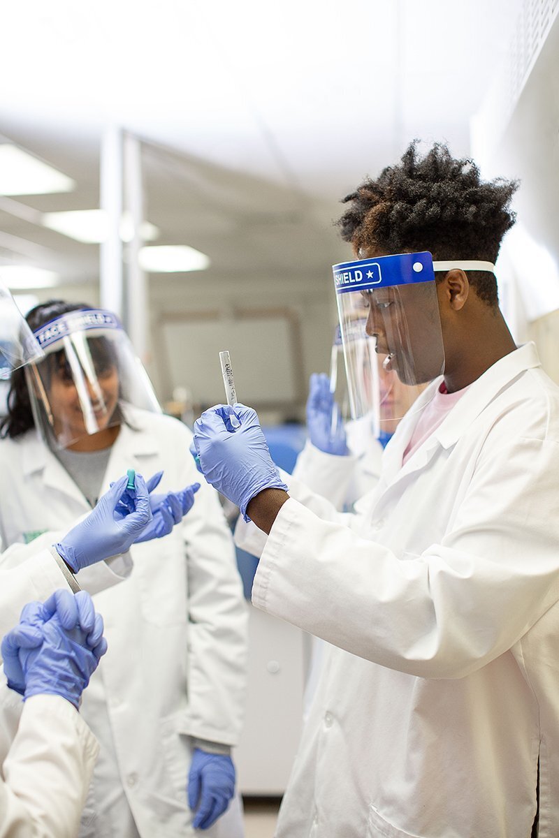 diverse students in lab looking at a test tube