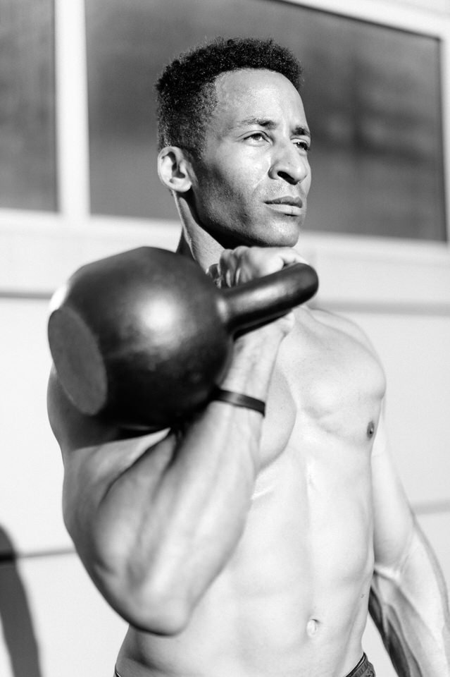 man holding a kettlebell for nyc photoshoot