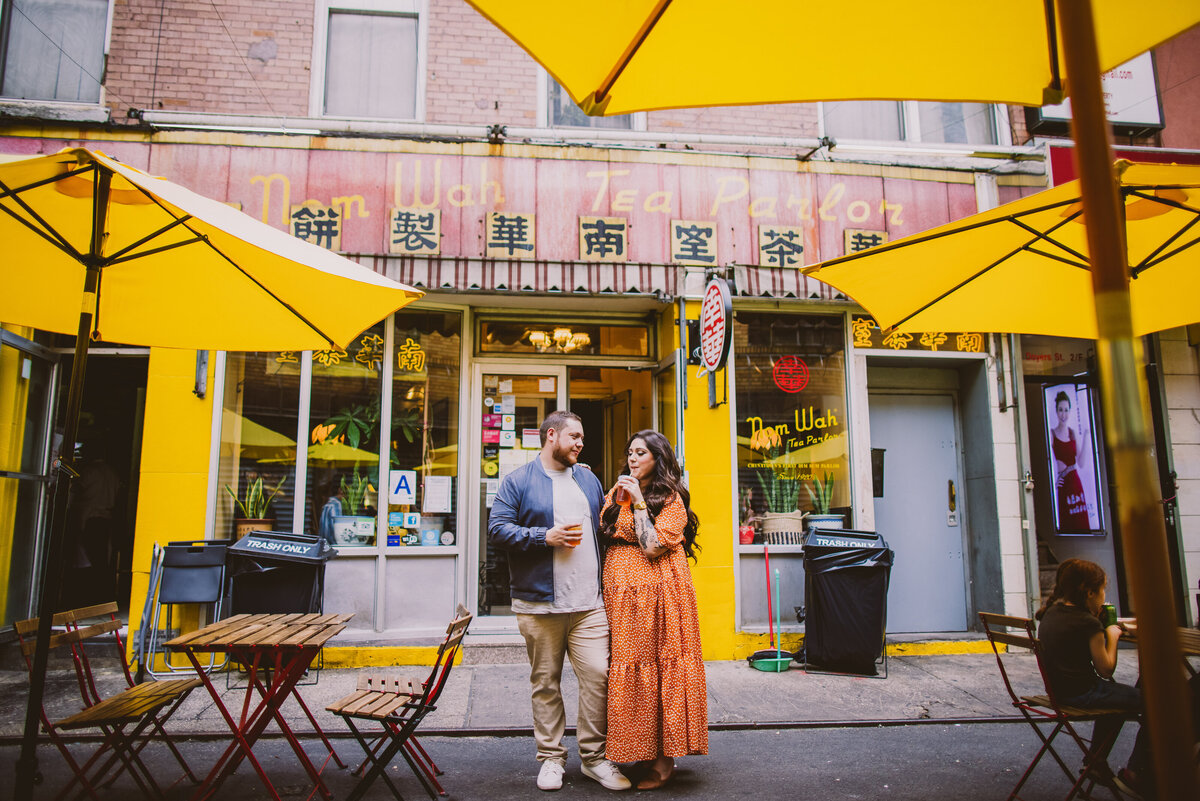 A couple drinking some iced tea outside of nom wah parlor in chinatown nyc