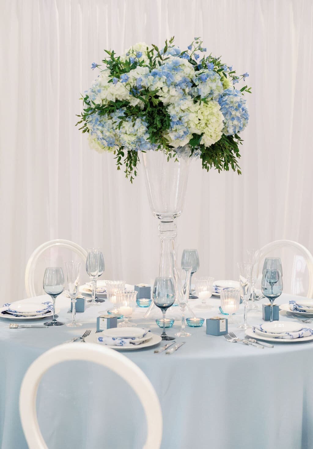 Stunning wedding reception centerpiece featuring blue and white hydrangeas and greenery, perfect for Maryland wedding floral arrangements.