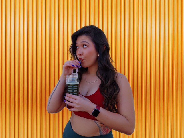 Jenni smiling while holding Arbonne wellness products, representing her authentic partnership and alignment with clean living and heart-led entrepreneurship