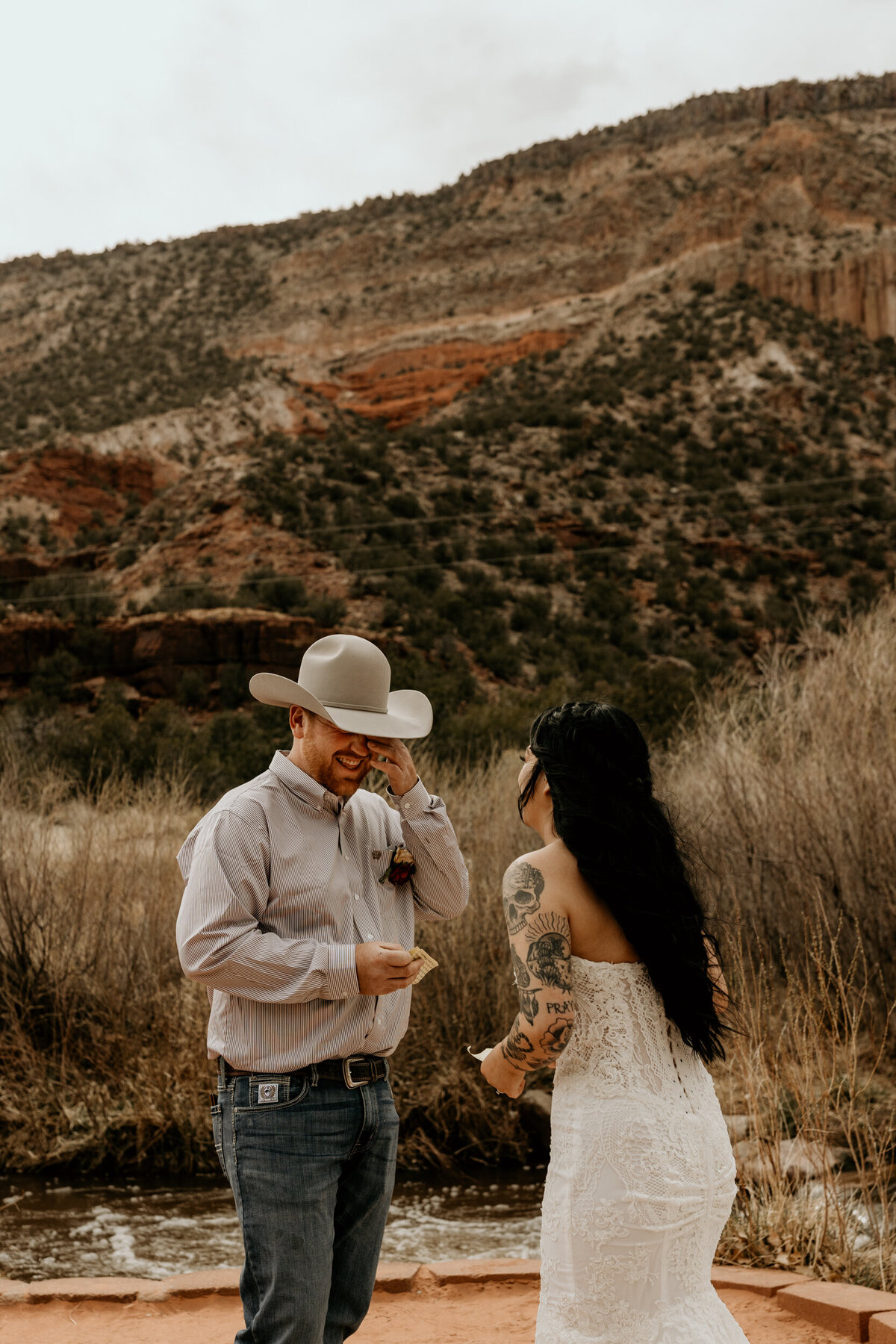 Bride and groom exchanging vows in front of the Jemez Springs red rocks