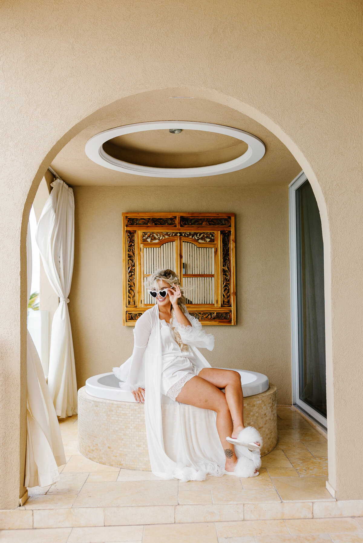 Bride sitting and laughing while getting ready, captured by Claudia Amalia Photography in Miami, Florida.