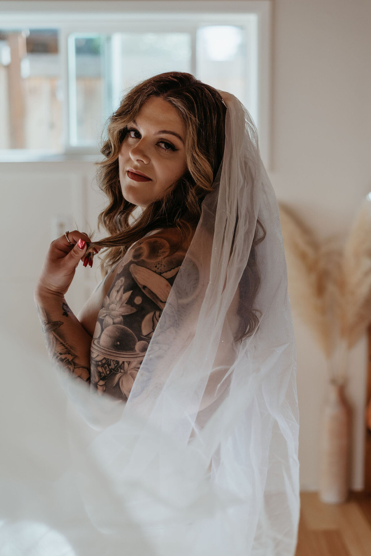 Woman in wedding veil poses for bridal boudoir  photos in Eugene, OR studio.