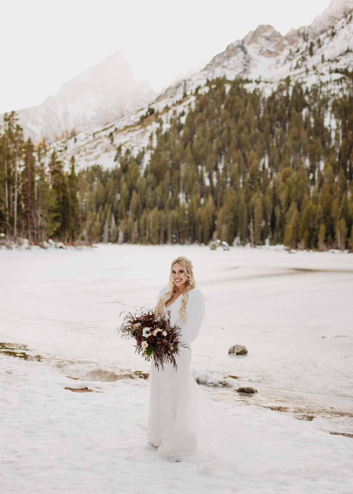 Jackson Hole Photographers capture bride in snow holding bouquet