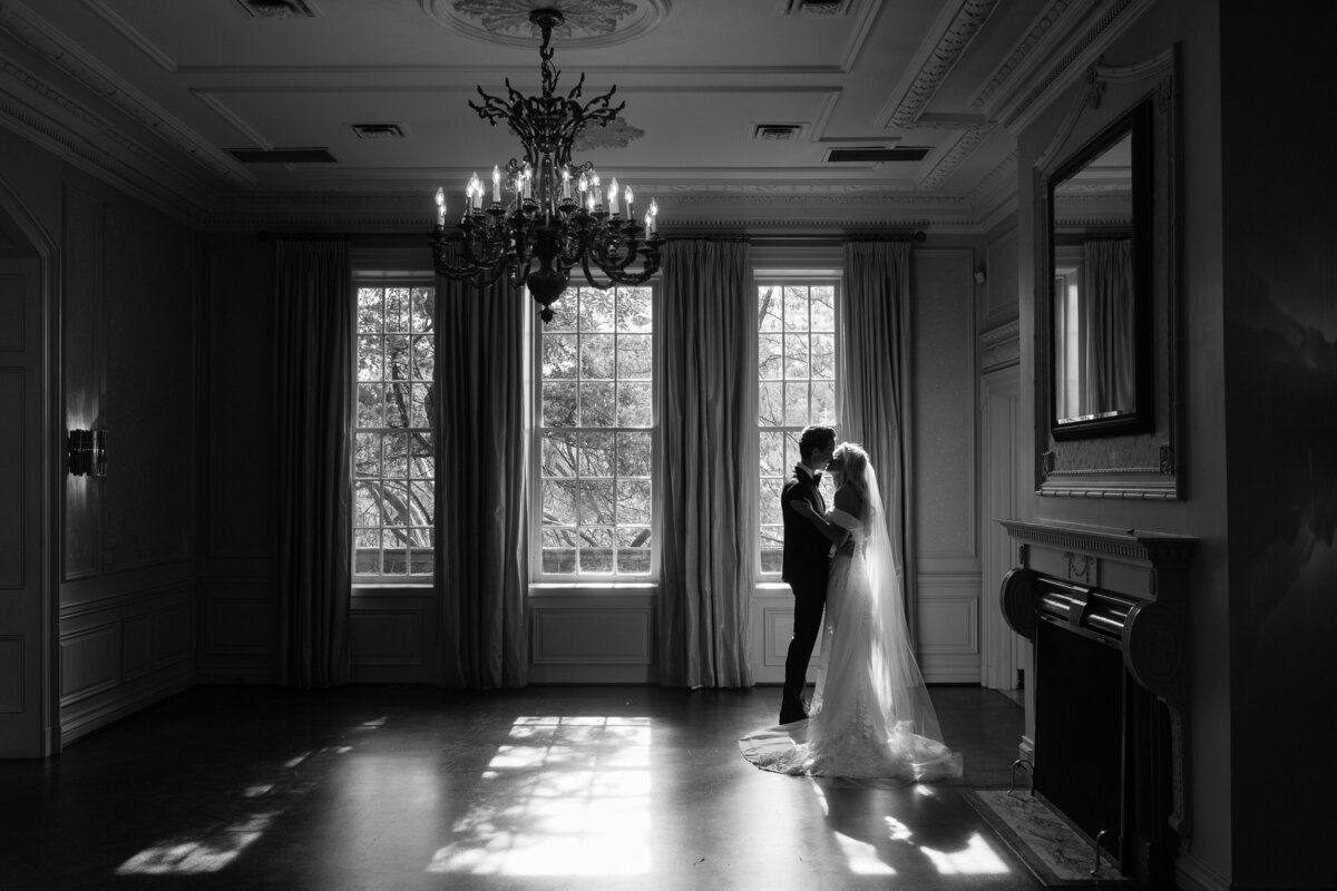 Couple in black and white embracing in the shadows at Graydon Hall Manor