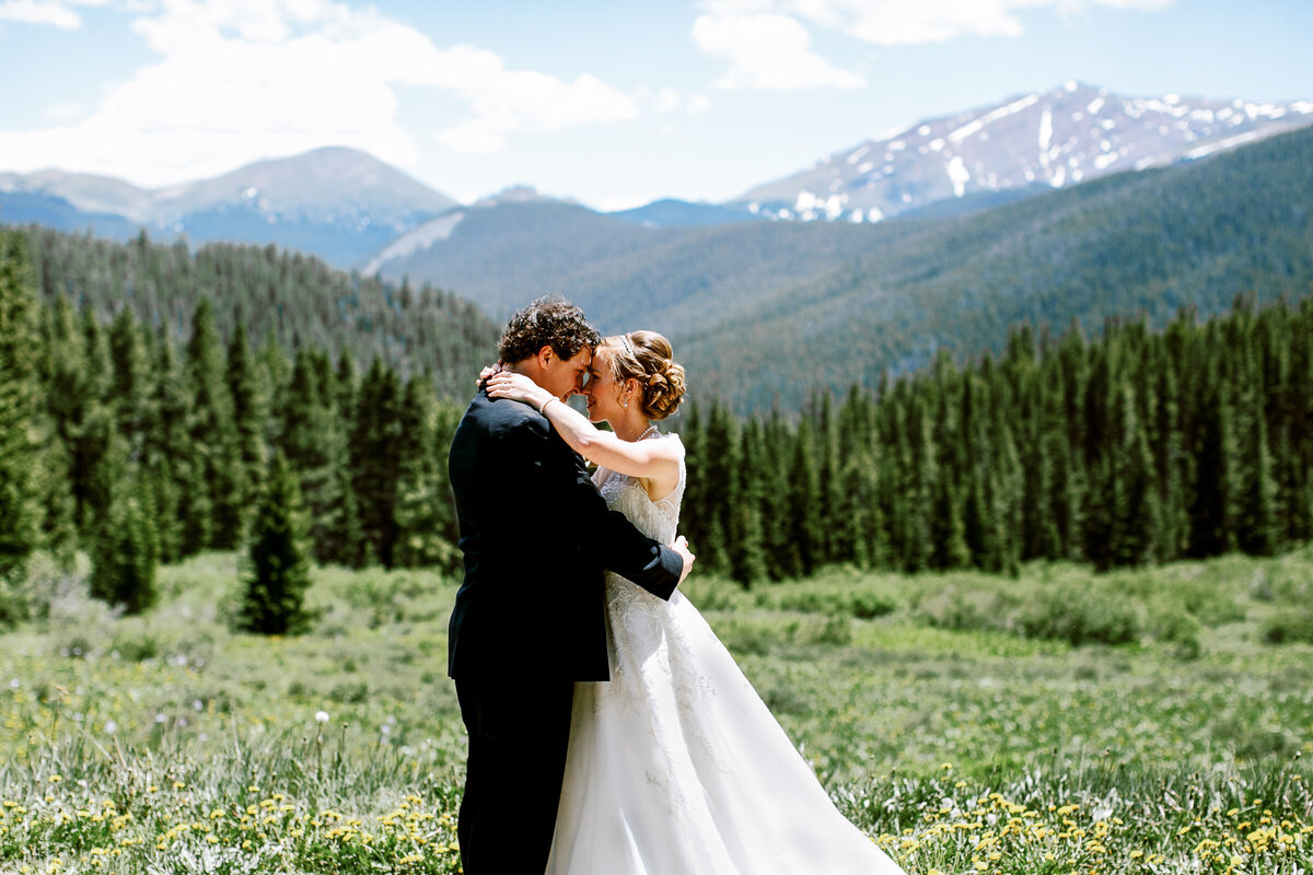 a wedding couple pose for photos in the Rocky Mountains in Breckenridge