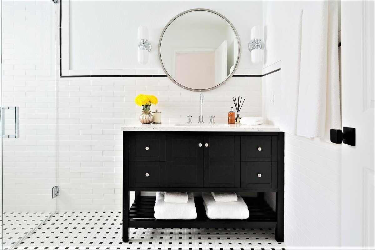 Elegant White Guest Bath Design with Black Vanity and Round Mirror