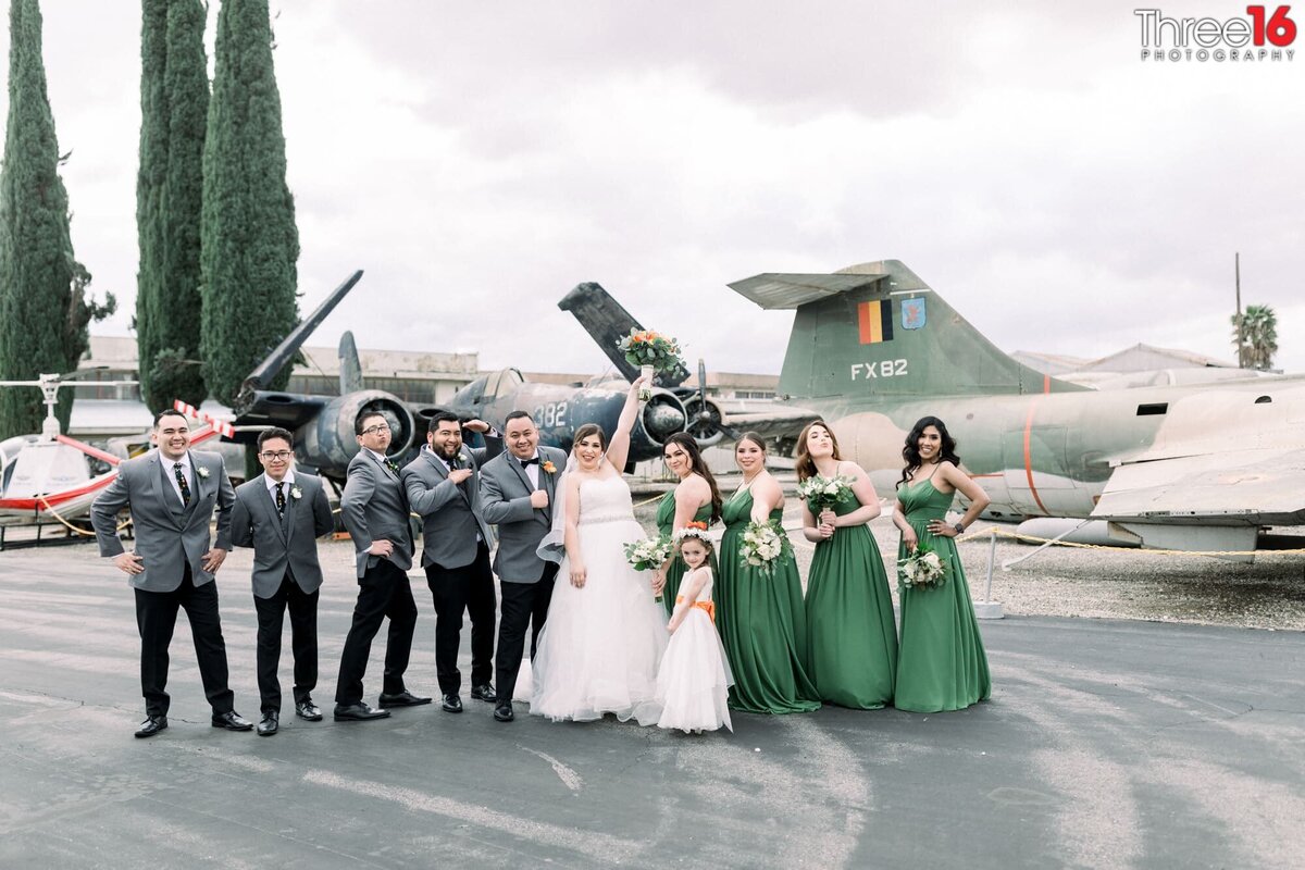 Newly married couple pose with their wedding party