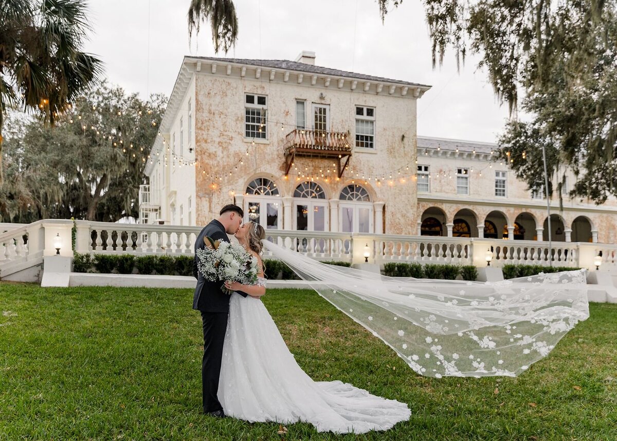 Bride and Groom kissing with veil flying at Bella Cosa, Lake Wales, Florida