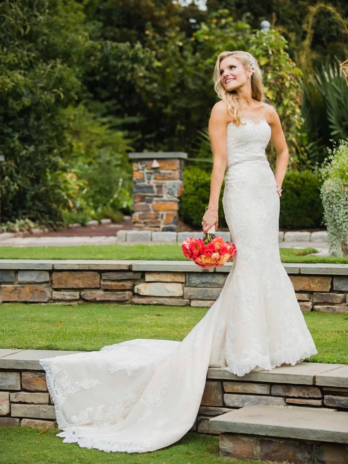 A bride standing on a small ledge looking over her shoulder
