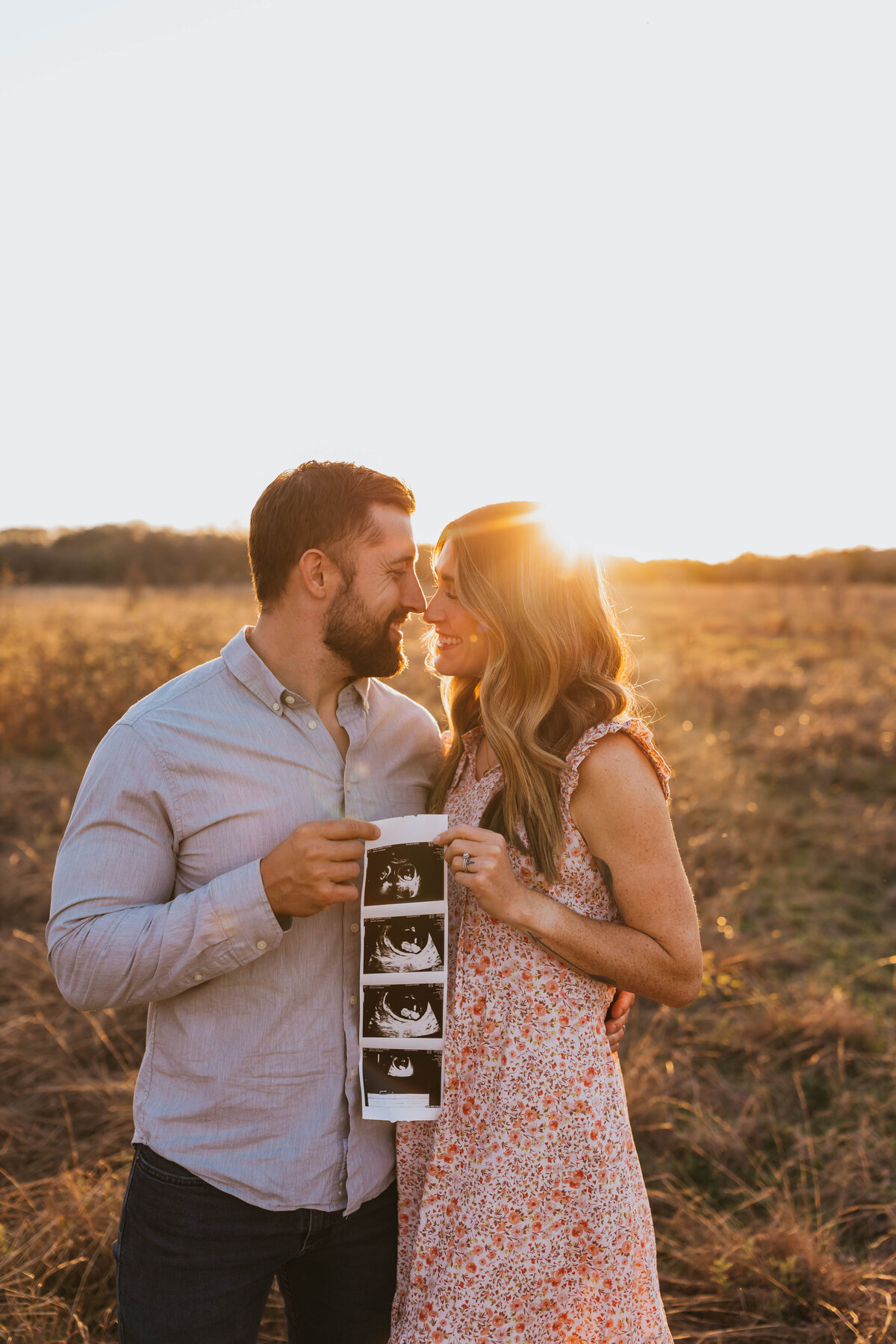 A couple holding a sonogram photo announcing their pregnancy