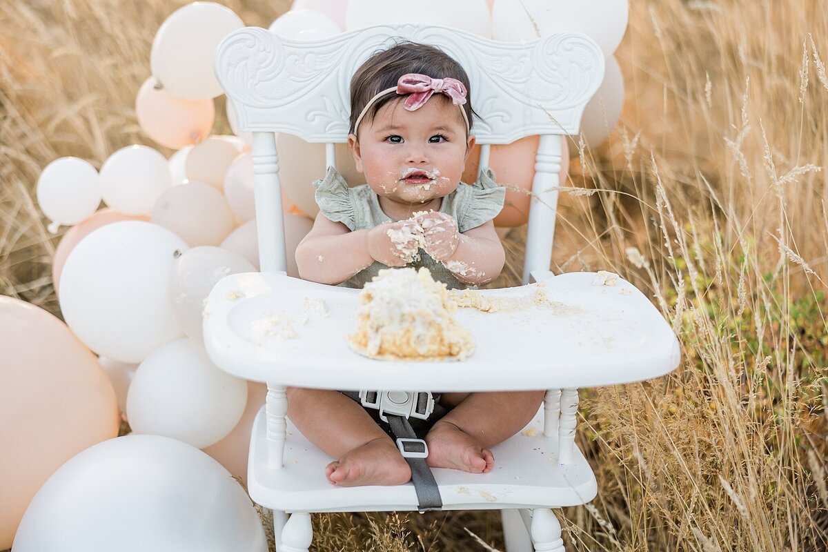 baby girl in vintage white high chair for cake smash session