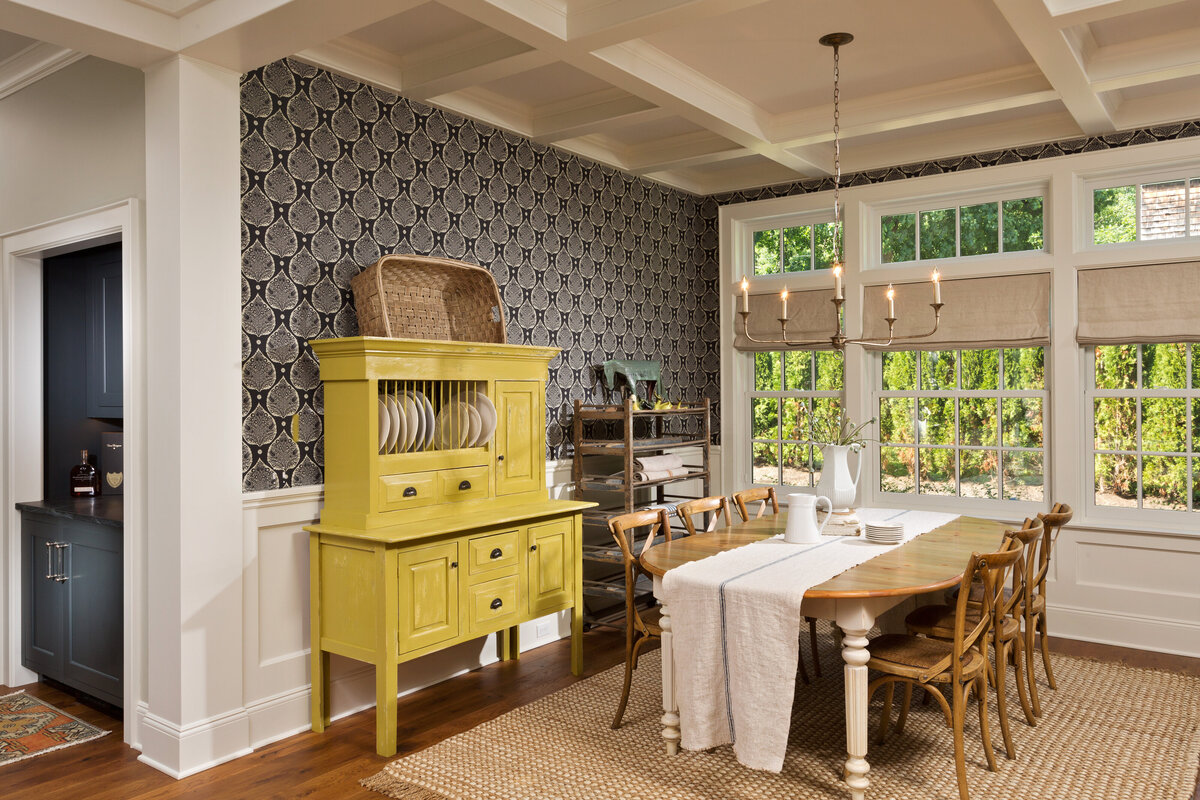 wallpapered dining room with yellow accent cabinet