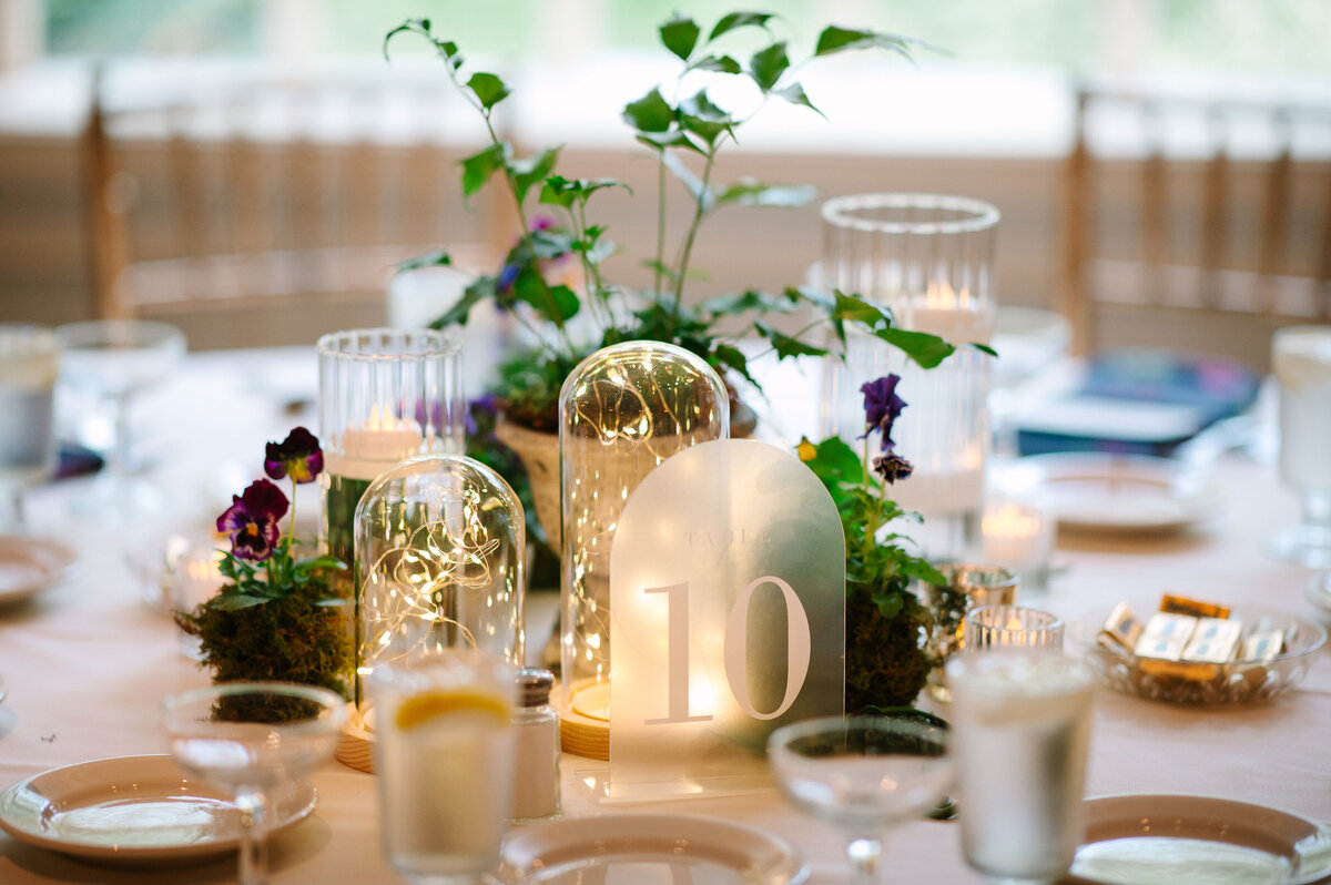 Close up of wedding tablescape of candles and greenery