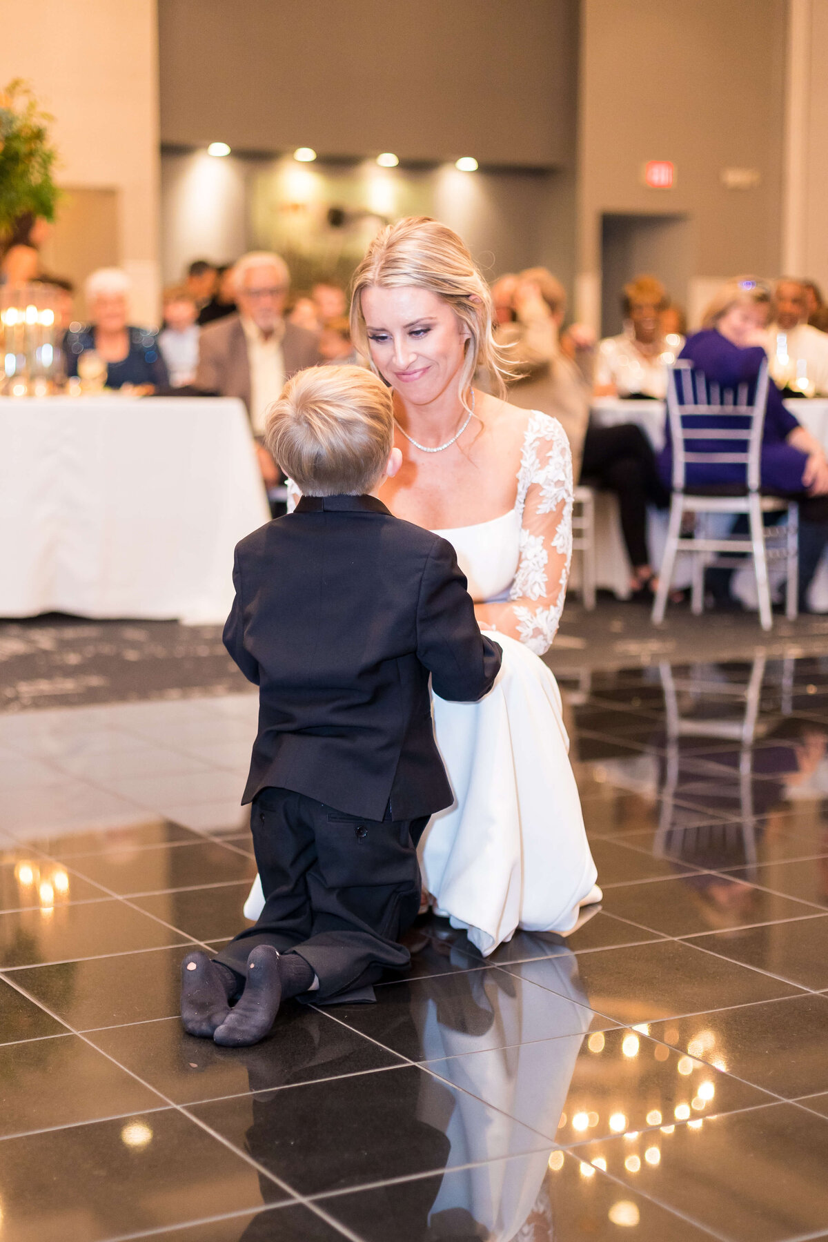 Bride bending down to talk to little boy at The Carrick House Wedding venue in Lexington, KY