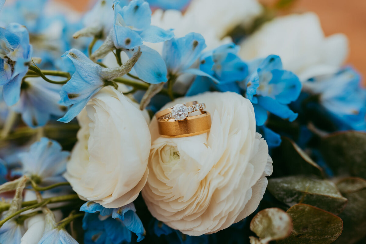 blue and white flowers holding wedding rings