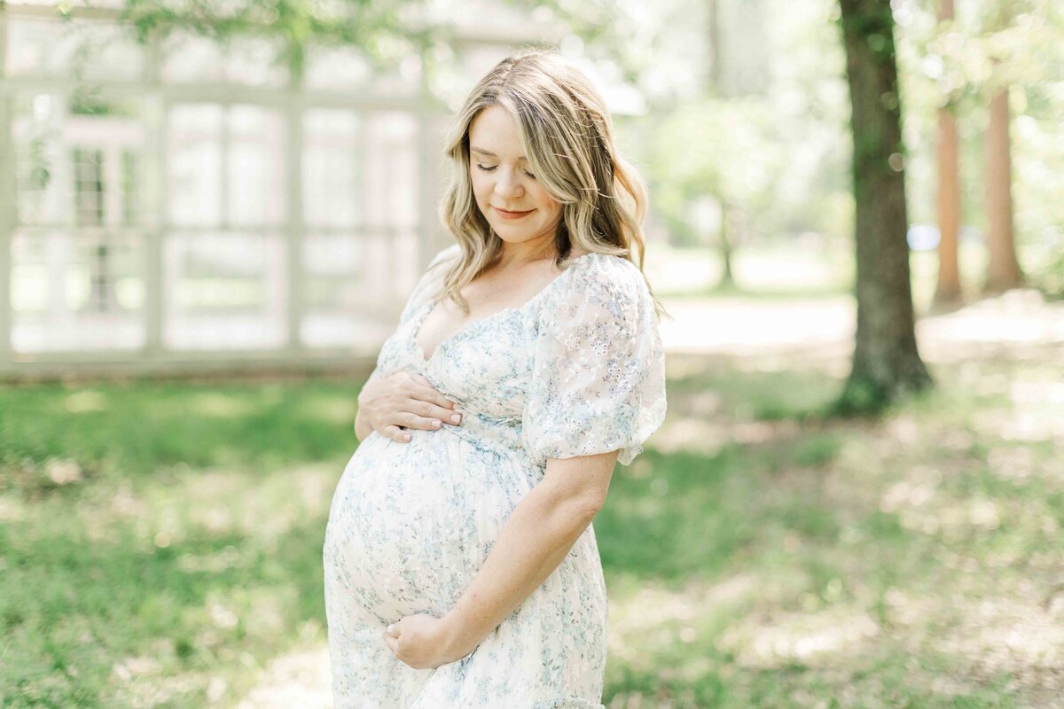Expecting mother holds her belly for maternity portrait
