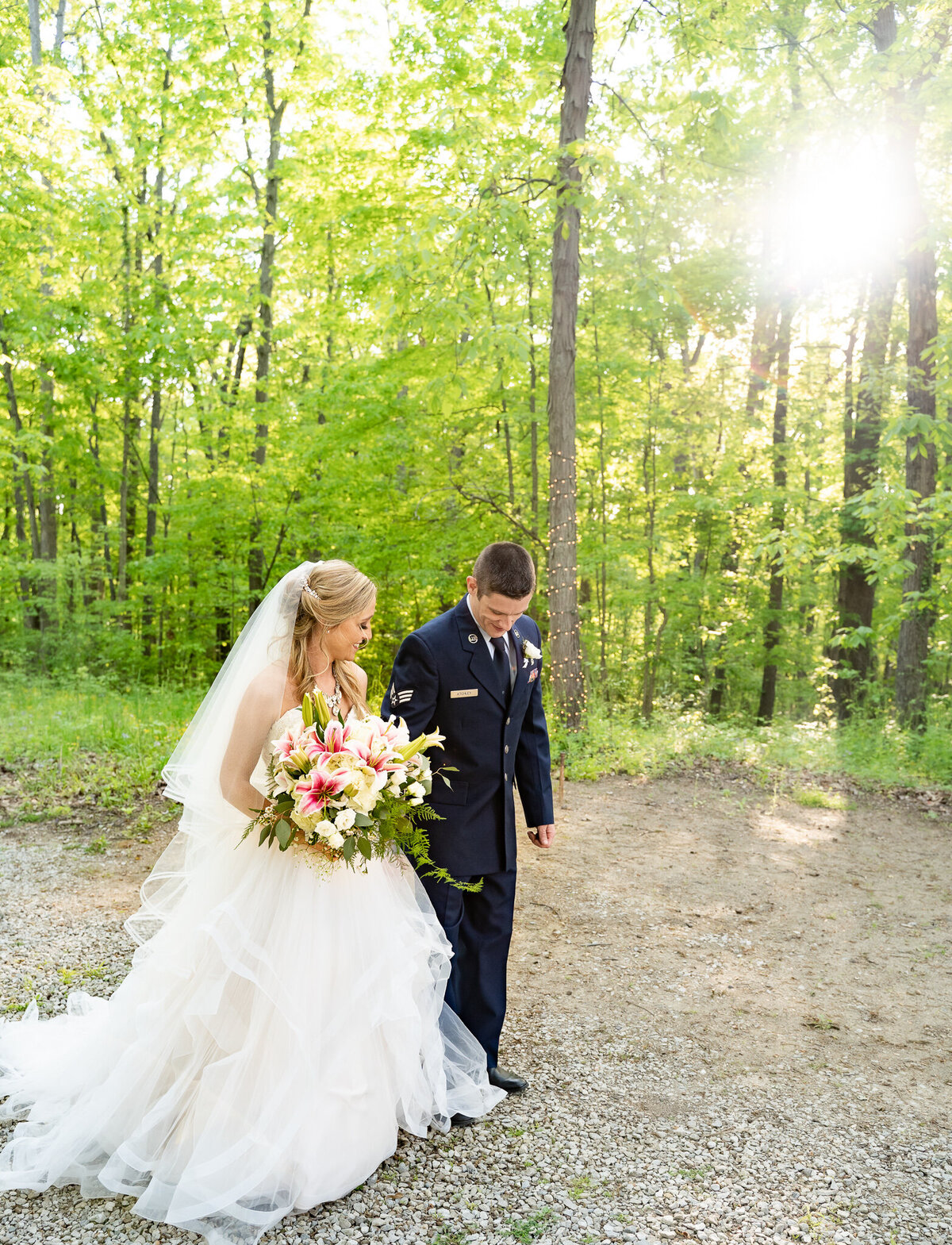 Bride and groom, Amber and Beau, walking in the woods on their wedding day at Cheers Chalet in Lancaster, Ohio.