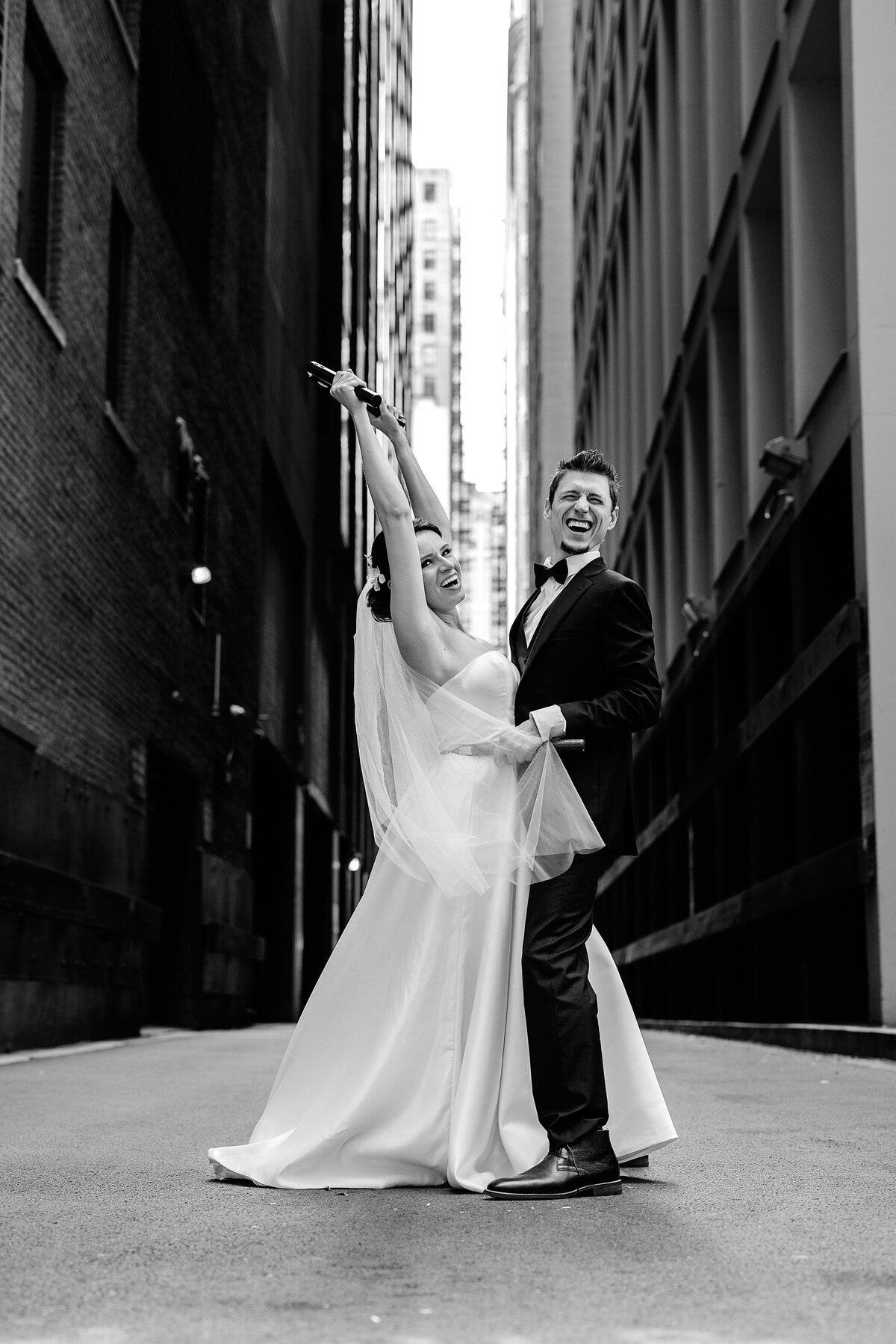 Groom pulled his bride in white wedding dress closer to him in nunchucks in Chicago