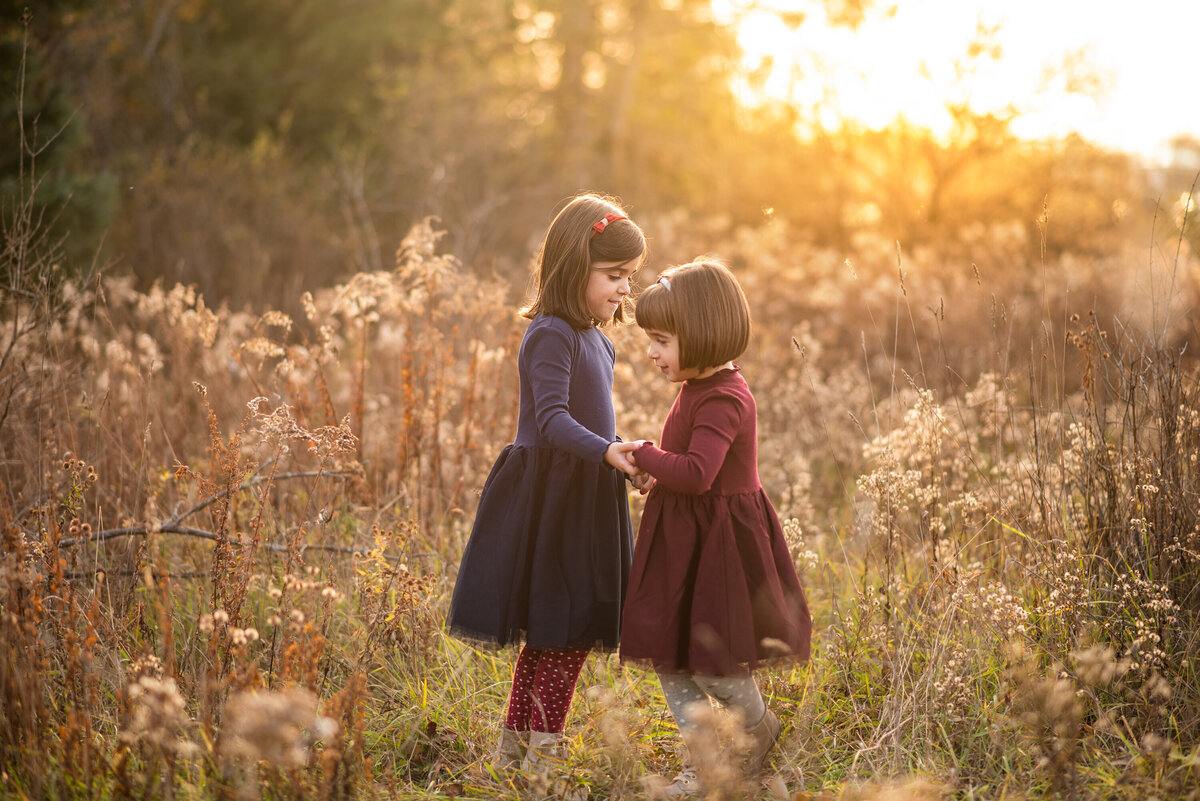 Sisters looking at each other in a field  at Old Quarry Trail.