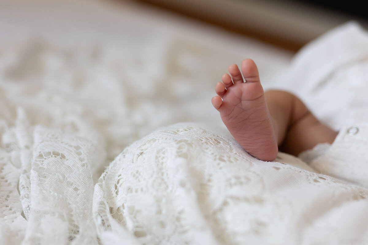 Baby foot with toes on the blanket at home photo session in Cochrane Alberta