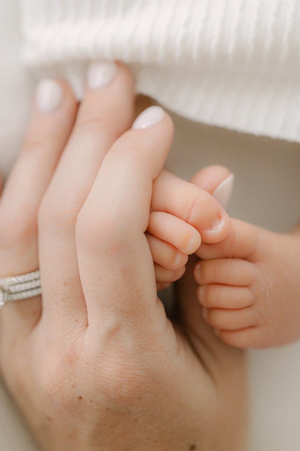 macro of a mother holding her newborn's feet during a session with Indianapolis newborn photographer, Brittney Lear.