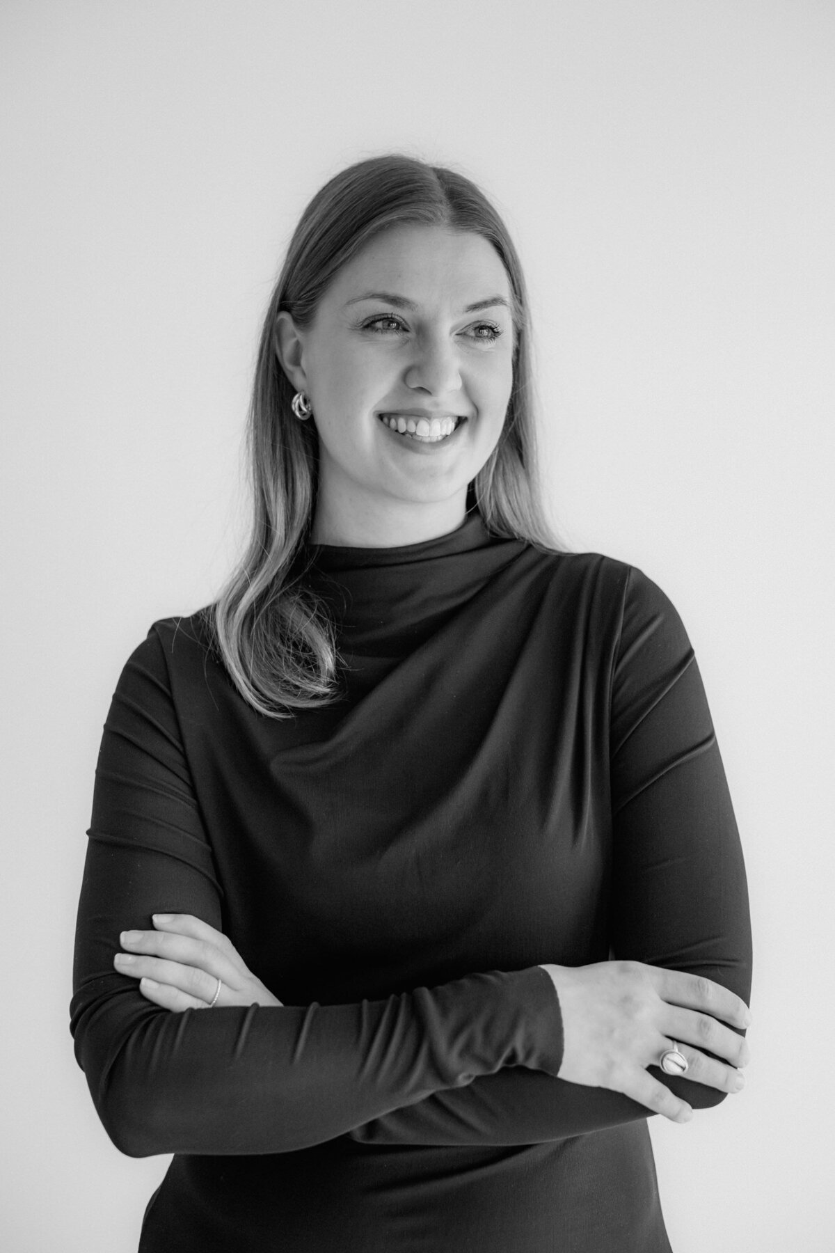 Portrait of smiling woman with arms crossed.
