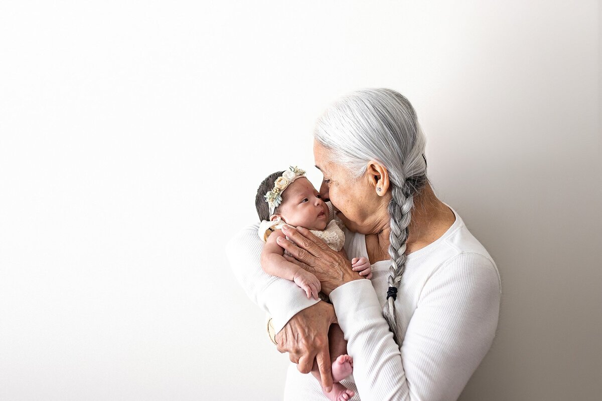 Grandma kissing newborn baby