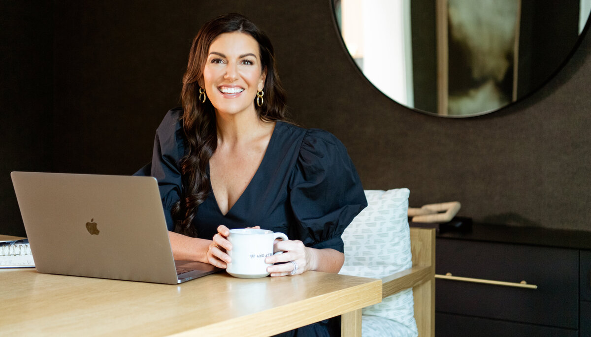 Amy Headshot in Orange Jacket Leaning on Counter - Online Marketing Expert