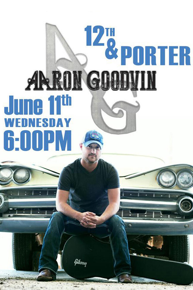 Concert promotion poster Artist Aaron Goodvin  in front of bumper of vintage car sitting on Gibson guitar case