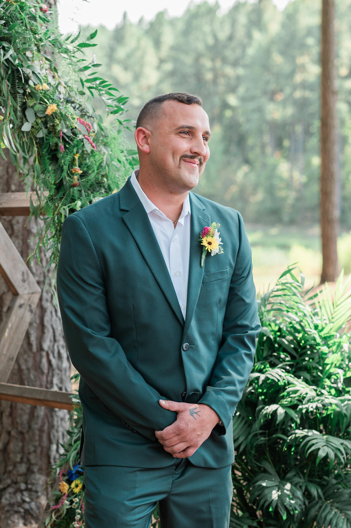 A man in a green suit smiling