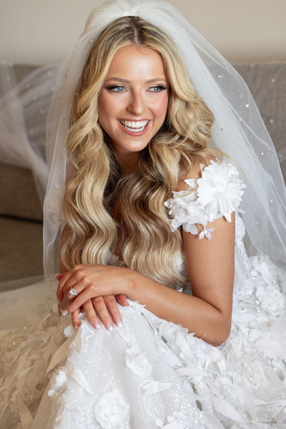 A bride sitting on a couch smiling