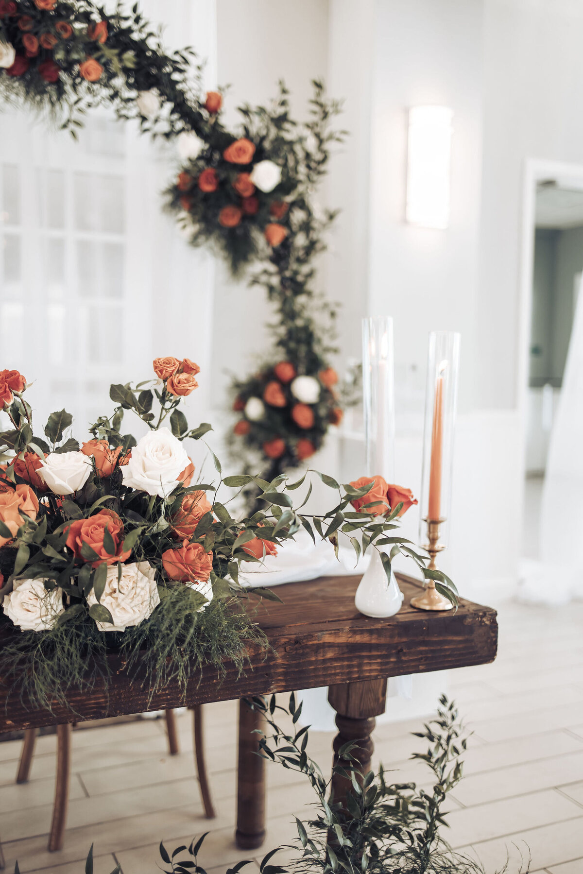 orange and white rose flower arch and bouquets