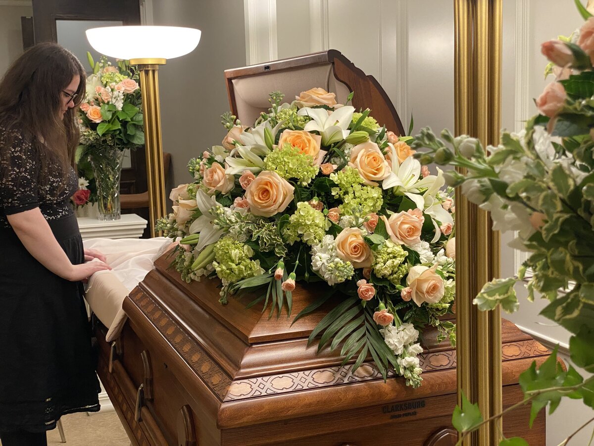 white lilies peach roses green hydrangea funeral casket flowers at White Pine Funeral Flowers
