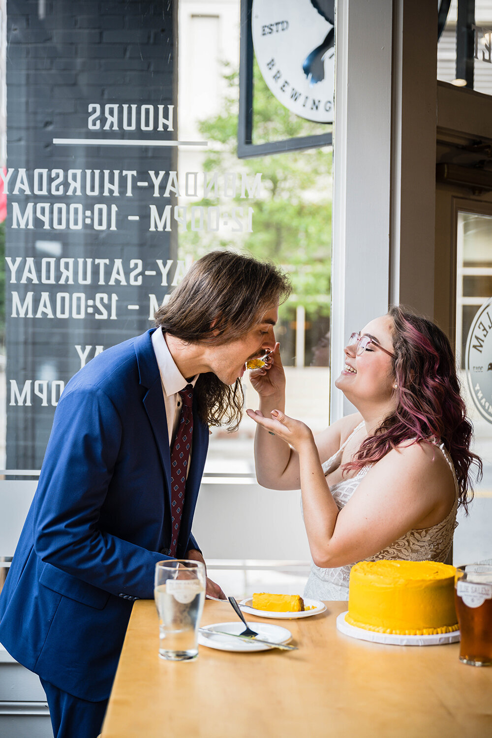 A newlywed spouse feeds a piece of cake to her significant other in Olde Salem Brewery in Downtown Roanoke on their elopement day.