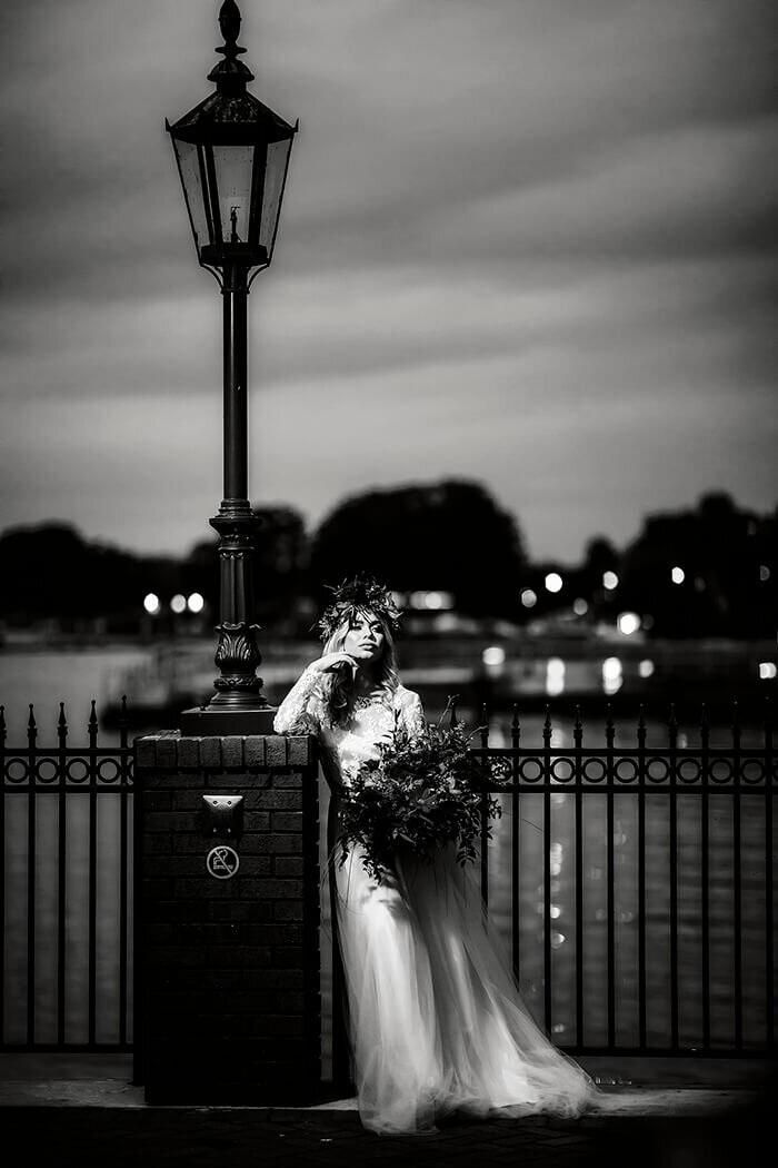 bride-stands-uner-lamp post-on-pier