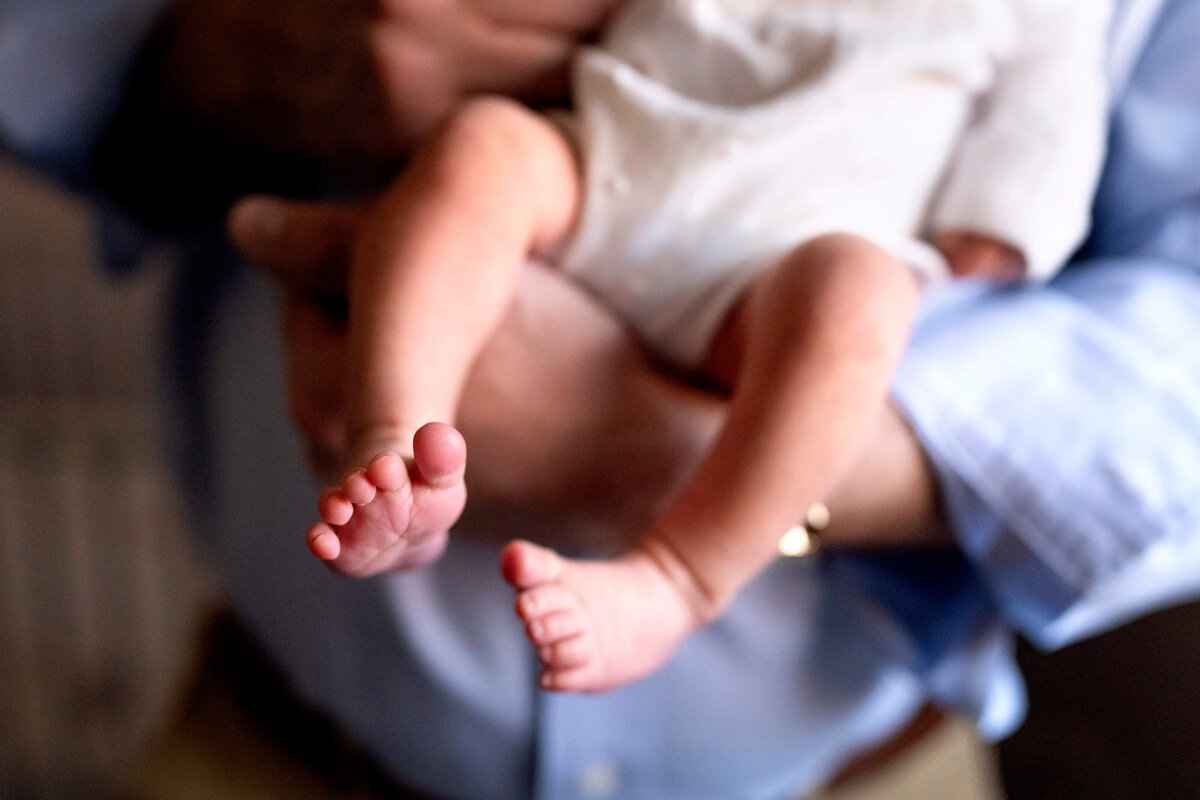 Detail image of baby feet while father is holding her