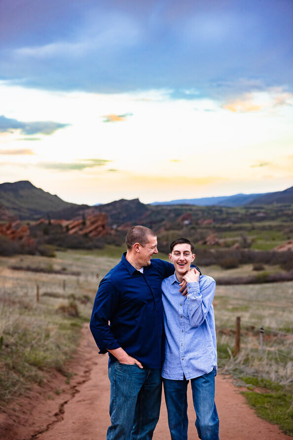 A dad looks at and hugs his son during family photos.