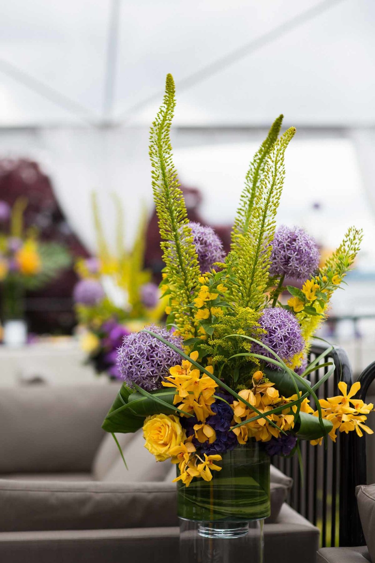 large flower arrangement of, large purple allium, yellow orchids, yellow eremurus, and yellow roses