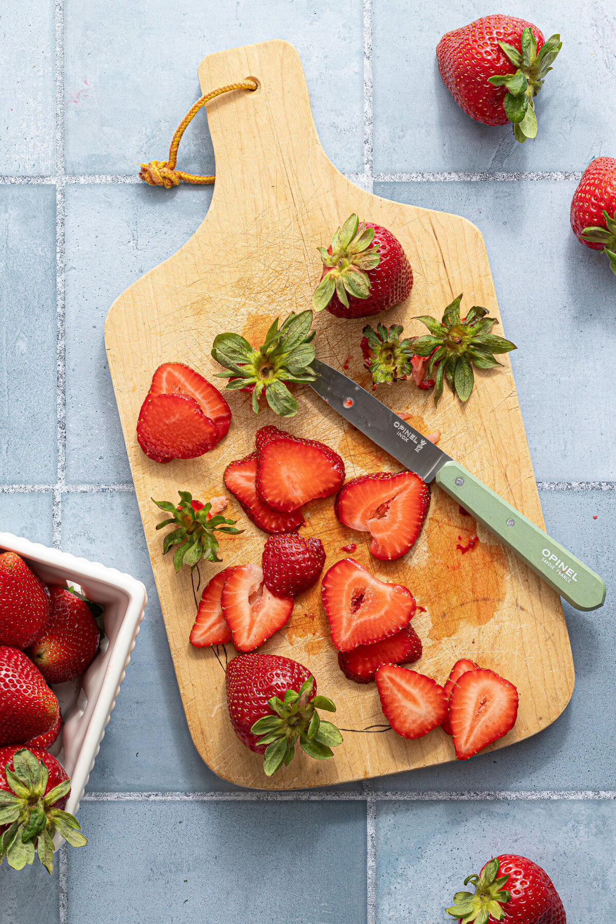 chopped strawberries on a wooden cutting board