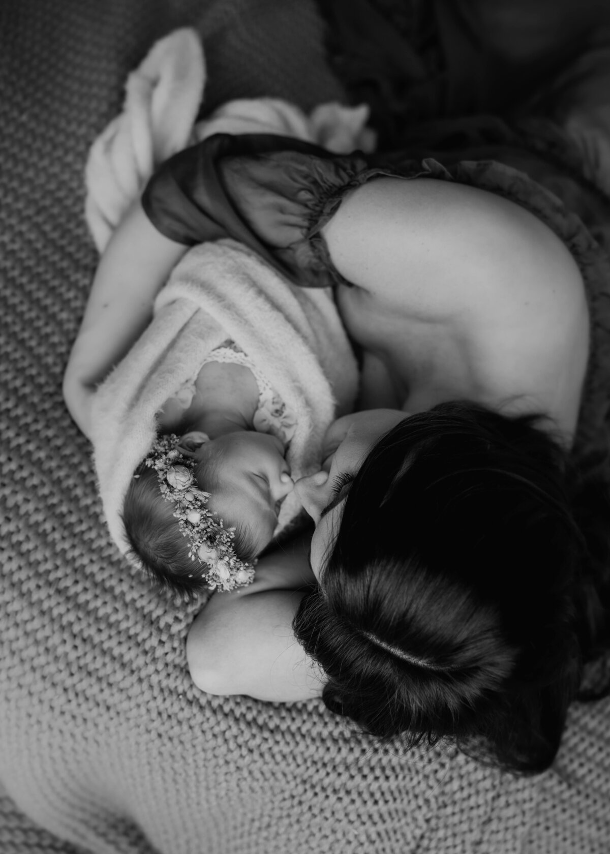 black and white portrait of mom in a gown holding her newborn baby girl