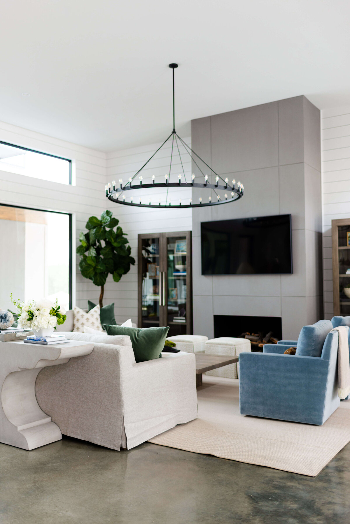 oyster creek studios building belt new build round accent lighting in living room with white sofa and blue chairs